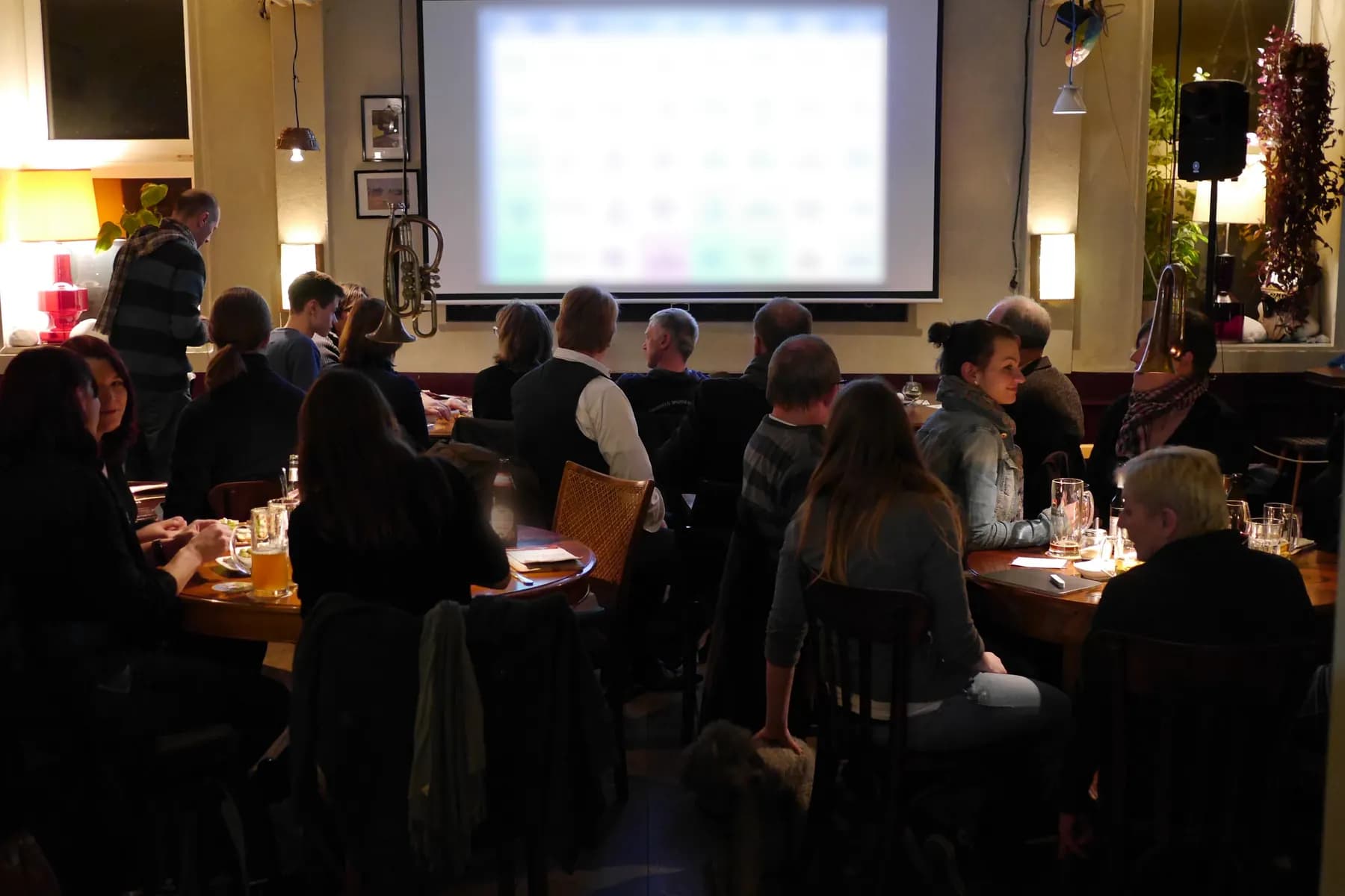 Le soir, dans un café-bar aux lampes chaudes, des équipes attablées autour de tables rondes, des bières devant elles, se tournent vers le grand écran où s’affiche la grille des questions d’un quiz.